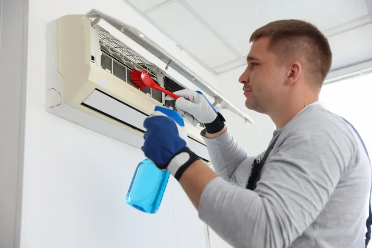 Tecnico professionista che pulisce un condizionatore interno a Treviso