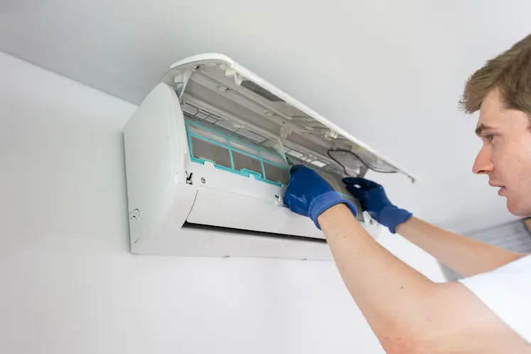 Tecnico che installa il filtro di un condizionatore interno a Bologna
