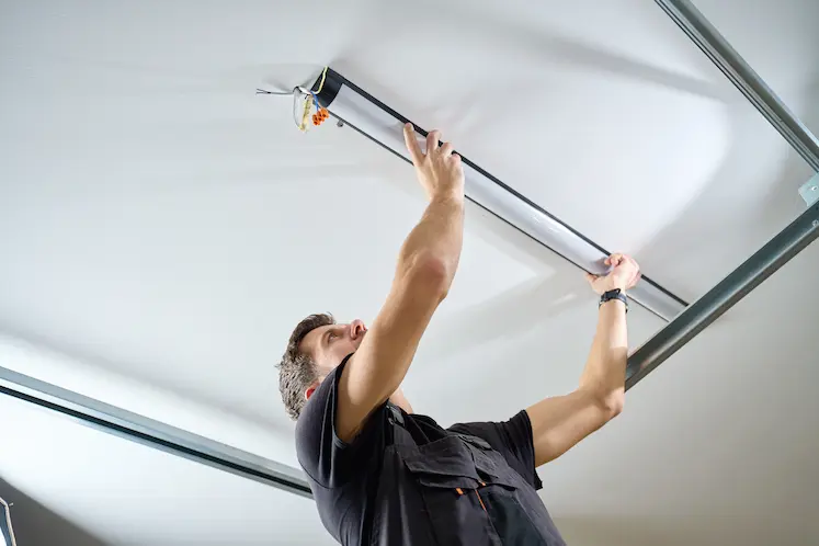 elettricista installa nuovo lampadario LED sul soffitto in appartamento del Friuli