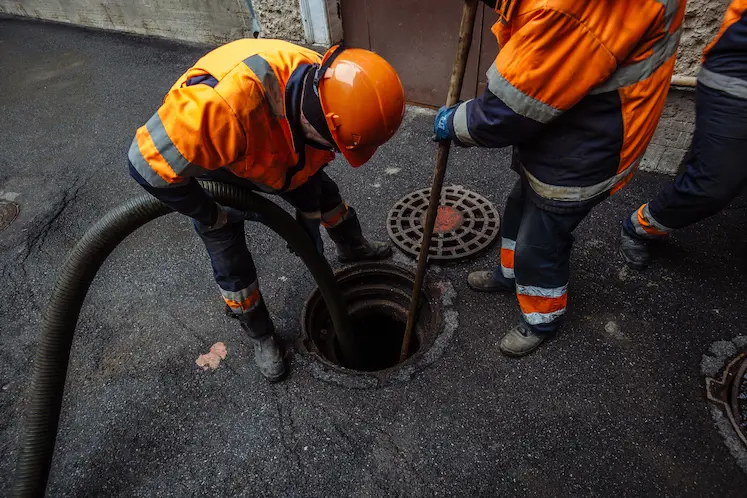 operai autospurgo intervengono su tombino stradale ostruito nel centro storico ligure